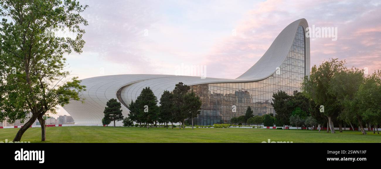 Das Heydar Aliyev Centre in Baku, Aserbaidschan, ist ein Beispiel für zeitgenössische Architektur mit seinem fließenden, wellenförmigen Design vor einem Sonnenuntergang Stockfoto