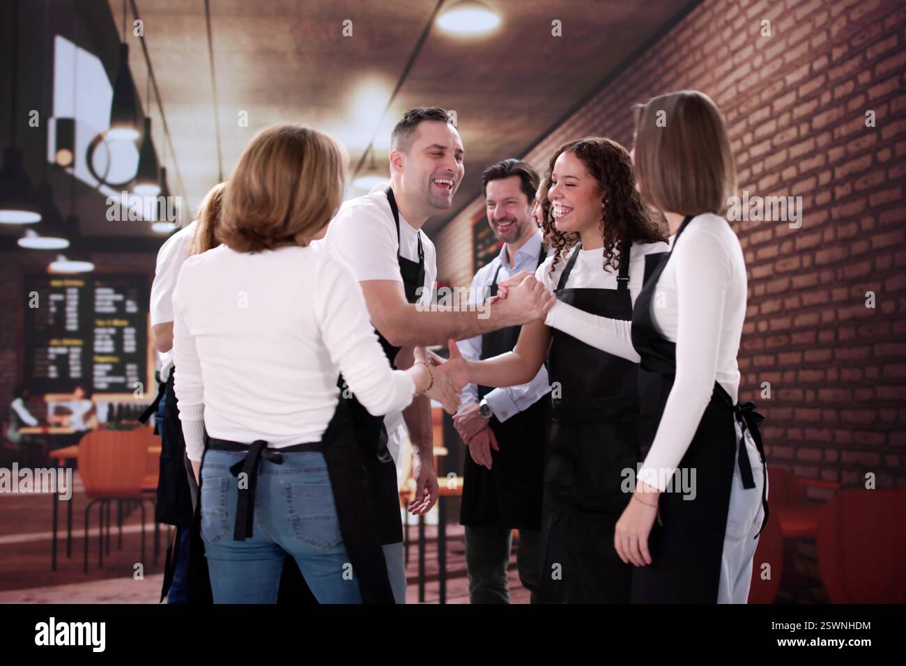Koch begrüßt neuen Mitarbeiter mit Handshake im Coffee Shop Stockfoto