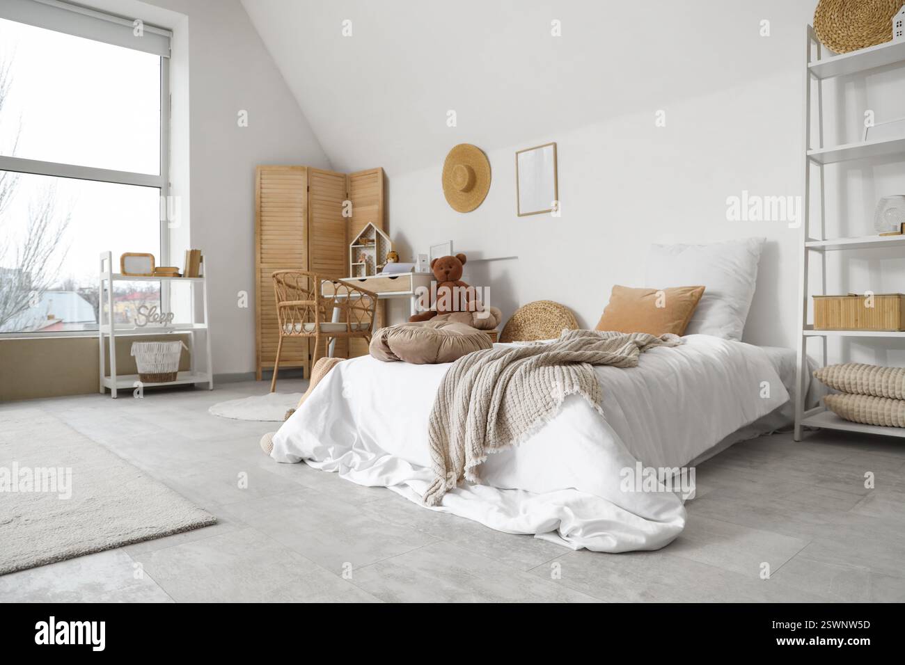 Innenraum des Kinderzimmers mit Bett, Tisch und Spielzeug Stockfoto
