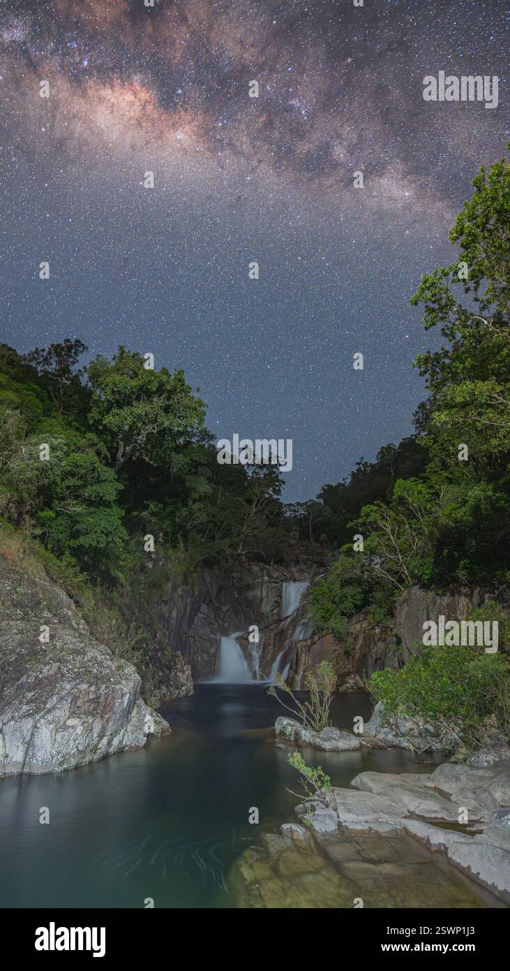 Ein atemberaubendes, hell gemaltes Nachtbild der Behana Gorge Falls, gekrönt vom milkyway-Kern in einer klaren Nacht in Far North Queensland, Australien. Stockfoto