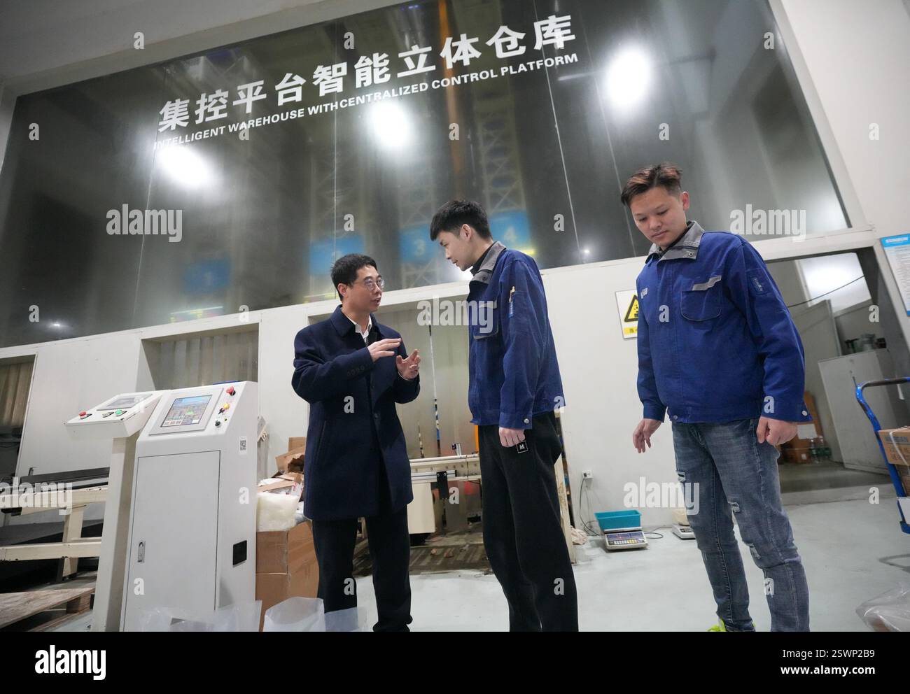 (250222) -- WENZHOU, 22. Februar 2025 (Xinhua) -- Hu Dongfang (L) erfährt am 18. Februar 2025 von einem Arbeiter in einem spezialisierten und innovativen Unternehmen in Wenzhou, ostchinesischer Provinz Zhejiang, über den Betrieb intelligenter Geräte. HU Dongfang, Abgeordneter des Nationalen Volkskongresses (NPC), ist stellvertretender Chefingenieur von Zhejiang Risesun Science and Technology Co., Ltd. In Wenzhou City. Er konzentriert sich auf die Forschung und Entwicklung von intelligenten Zählern und Ladepfählen und hat 24 zugelassene Erfindungspatente erhalten. Vom normalen Arbeiter zum bekannten Gussformkonstrukteur in der Branche, Stockfoto