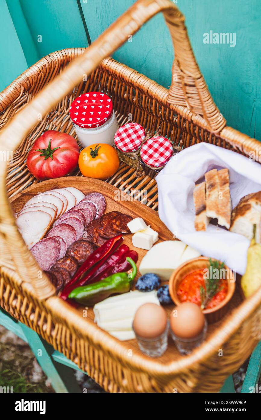 Korb mit frischen Produkten, Käse, Brot und hausgemachten Aufstrichen. Stockfoto