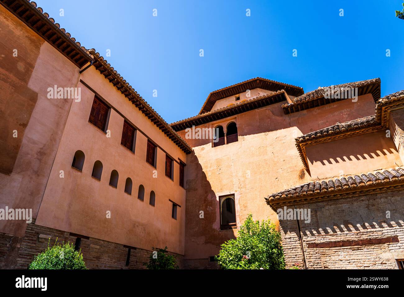 Innenhof hinter der Alhambra in Granada – rustikale maurische Architektur und sonnendurchflutete andalusische Wände Stockfoto