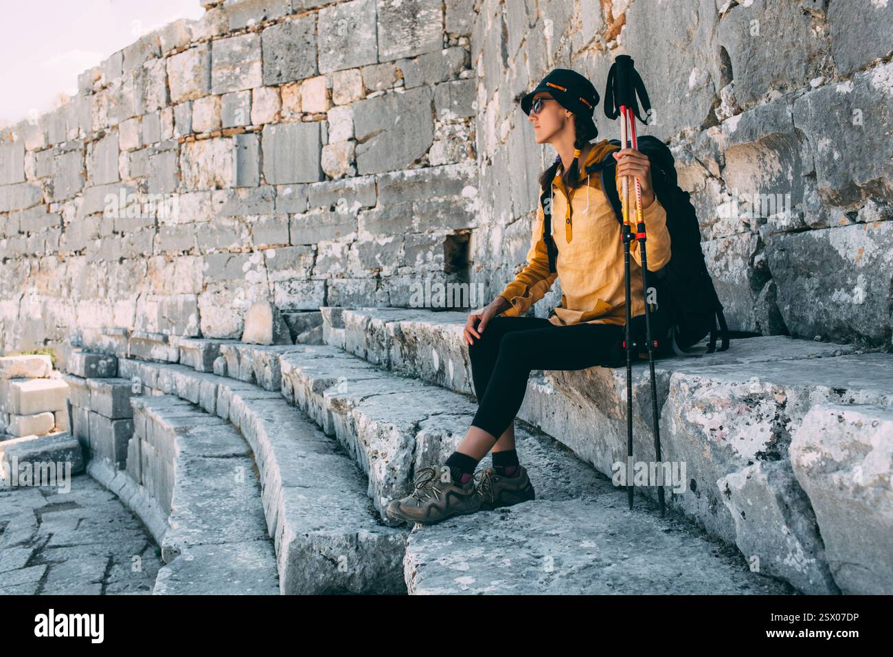 Die Reisende Frau ruht sich aus und sitzt auf den Stufen des Amphitheaters. Wandern in der Türkei, Lykischen Weg, Ksantos Stockfoto
