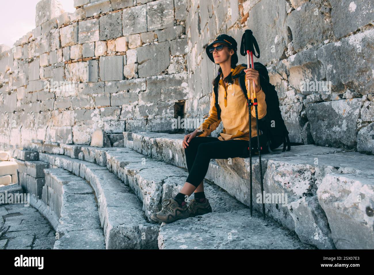 Die Reisende Frau ruht sich aus und sitzt auf den Stufen des Amphitheaters. Wandern in der Türkei, Lykischen Weg, Ksantos Stockfoto