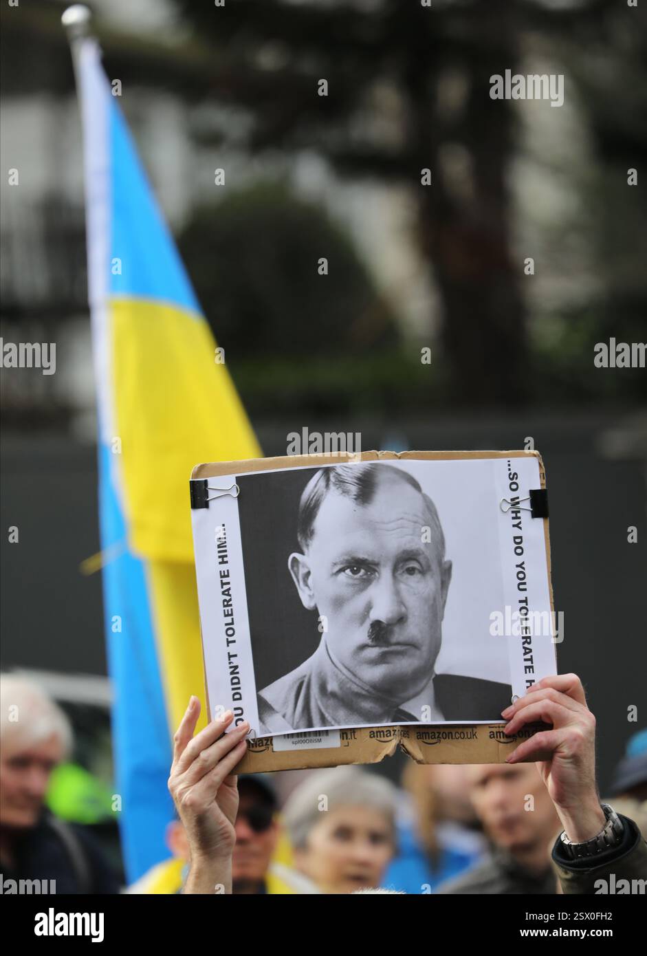 London, England, Großbritannien. Februar 2025. Ein Demonstrant hält ein Schild, das Putin und Hitler während der Demonstration vergleicht. Demonstranten aus der Ukraine und ihre Unterstützer versammeln sich im Westen Londons, um zu protestieren und zur russischen Botschaft zu marschieren. Sie verlangen, dass russische Truppen ukrainischen Boden verlassen und nach Hause zurückkehren. Sie bestehen auch darauf, dass jeder Deal Ukranianer einbeziehen muss und dass es sich nicht NUR um einen Zusammenschluss zwischen Putins Russland und der Trump-Regierung in den Vereinigten Staaten handeln darf (Credit Image: © Martin Pope/ZUMA Press Wire). Nicht für kommerzielle ZWECKE! Stockfoto