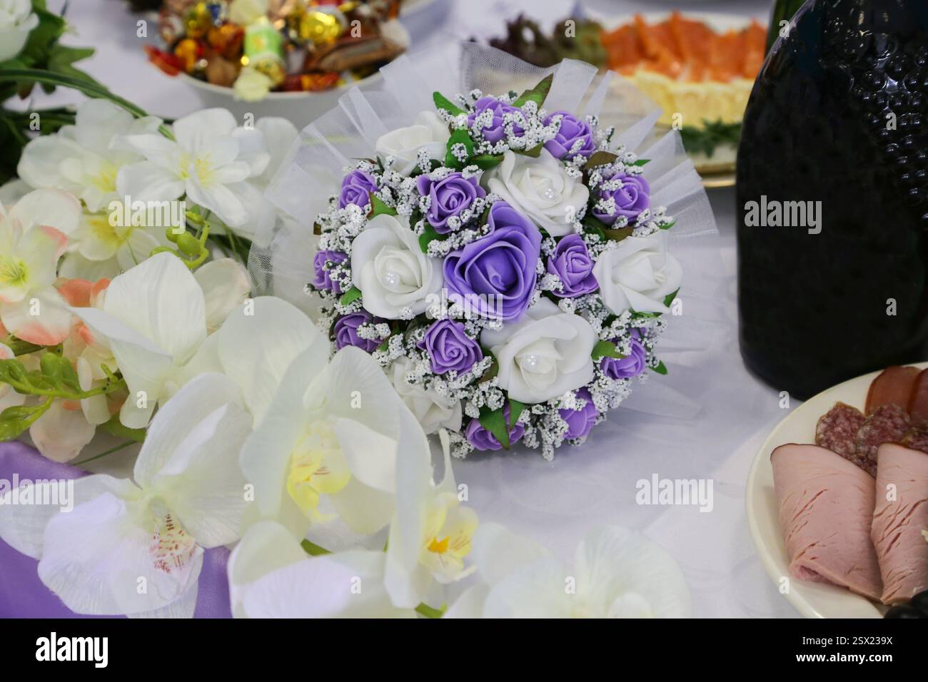 Der Blumenstrauß der Braut liegt auf dem Hochzeitstisch. Stockfoto