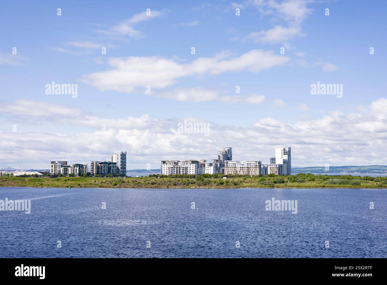 Moderne Entwicklung von Hochhauswohnungen an der Nordseeküste, mit blauem Wasser und Himmel. Edinburgh, Schottland, Großbritannien Stockfoto
