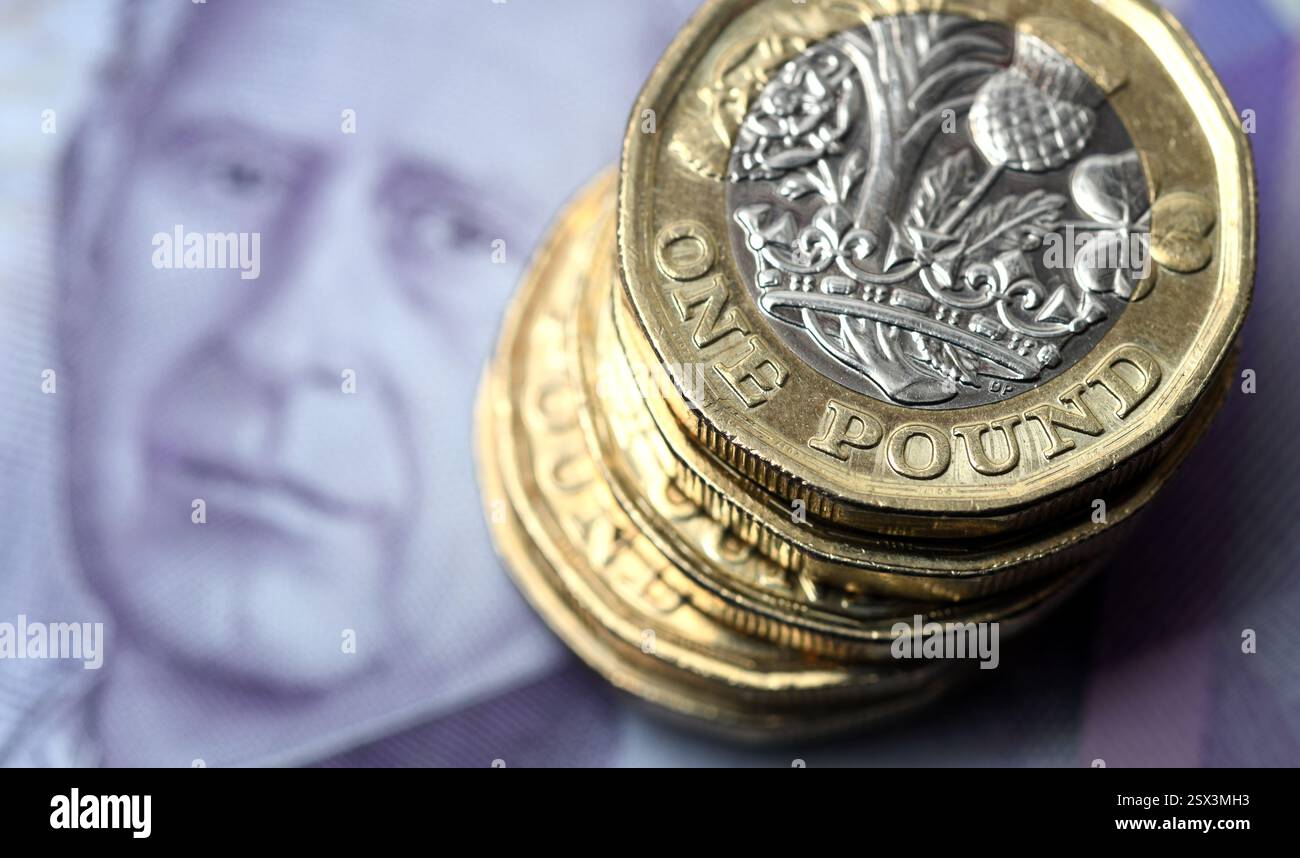 1-PFUND-MÜNZEN MIT BRITISCHEN BANKNOTEN RE HYPOTHEKEN SPAREN DIE WIRTSCHAFT RUHESTAND USW. GROSSBRITANNIEN Stockfoto
