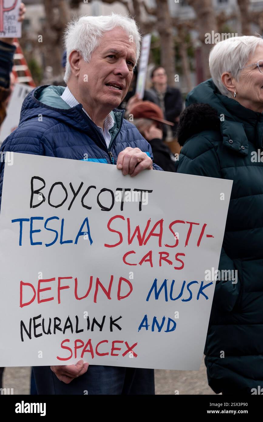 San Francisco, Kalifornien, USA, 17. Februar 2025. Ein Demonstrant hält ein Schild mit der Aufschrift "Boykott Tesla Hakenkreuze; Defund Musk, Neuralink und SpaceX", bei einem Protest gegen die Aktionen von Präsident Donald Trump und Elon Musk während des Präsidenten-Tages "No Kings" im Rathaus von San Francisco. Hunderte von Demonstranten kamen zu dem Grassroots Event. Quelle: Shelly Rivoli/Alamy Stockfoto