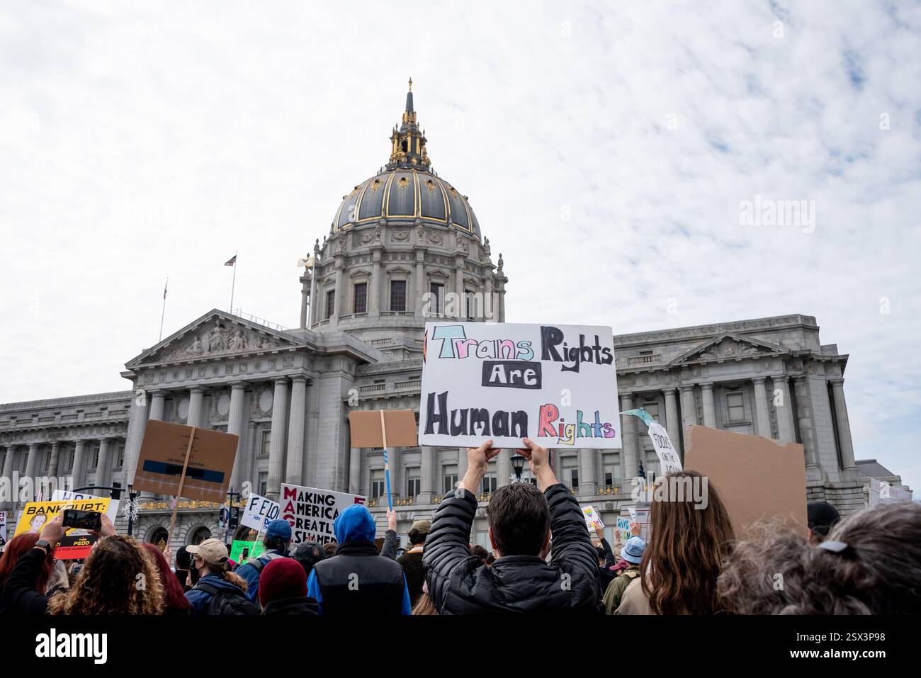 San Francisco, Kalifornien, USA, 17. Februar 2025. Hunderte versammeln sich vor dem Rathaus von San Francisco bei einem „No Kings“-Protest gegen die jüngsten Aktionen von Präsident Donald Trump und Elon Musk. Über der Menge steht auf einem Schild: "Trans Rights are Human Rights". Quelle: Shelly Rivoli/Alamy Stockfoto