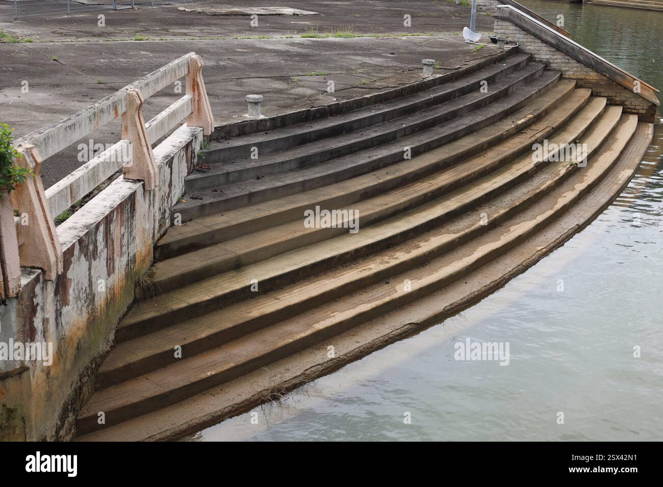 Geschwungene Betontreppen (Treppen), die von Bootsankern über dem Wasser hinunter führen Stockfoto