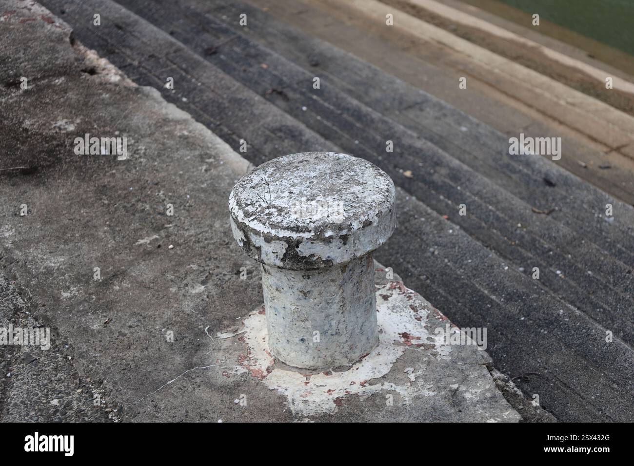 Die Anlegestelle für Betonboote braucht frische Farbe über abgenutzten Betonstufen bis zum Wasserrand Stockfoto