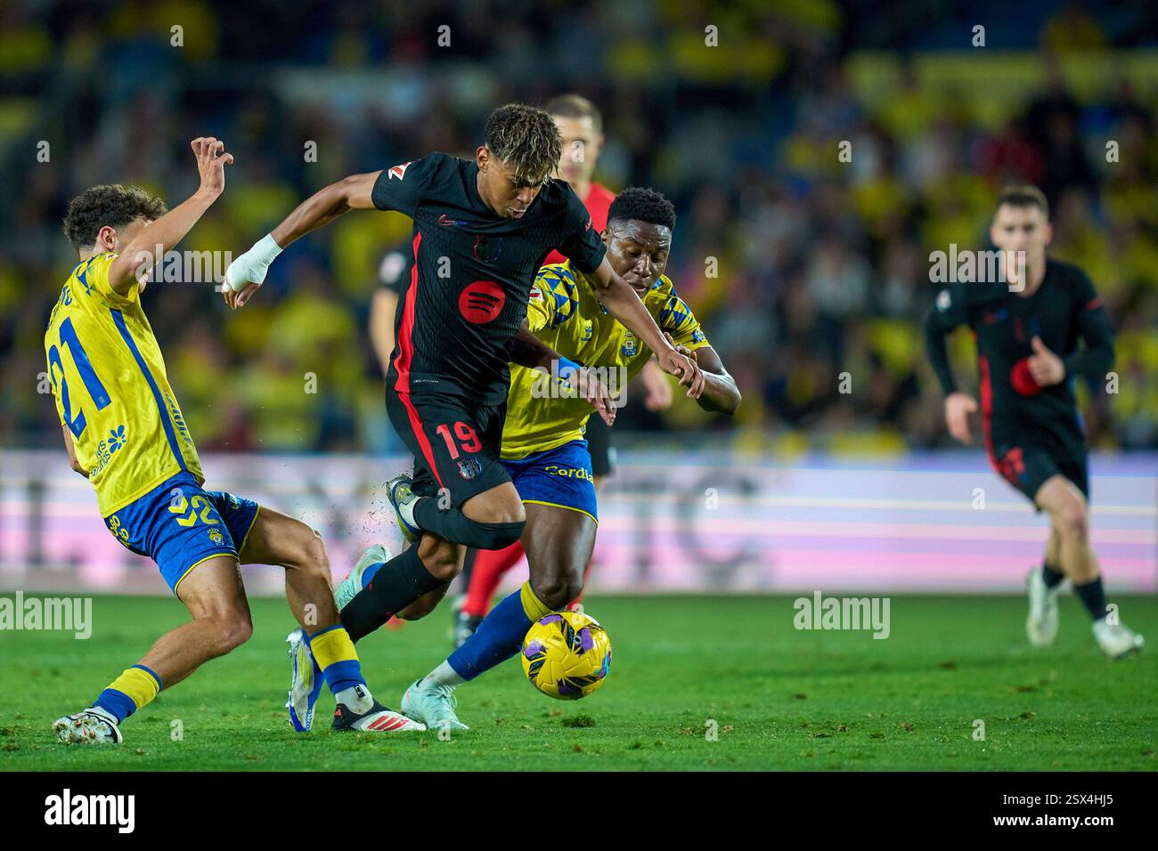 Barcelona's Lamine Yamal, second left, duels for the ball with Las Palmas' Stefan Bajcetic, left, during the Spanish La Liga soccer match between Las Palmas and Barcelona at the Gran Canaria stadium in Las Palmas, Spain's Canary Islands, Saturday, Feb. 22, 2024. (AP Photo/Gabriel Jimenez) Stockfoto