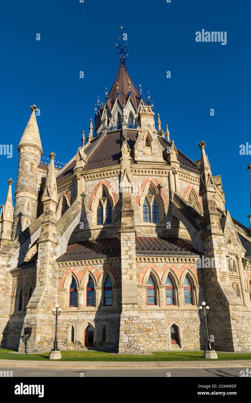 Großes Steingebäude mit einem Turm und einem Kreuz oben. Das Gebäude ist von Gras umgeben Stockfoto