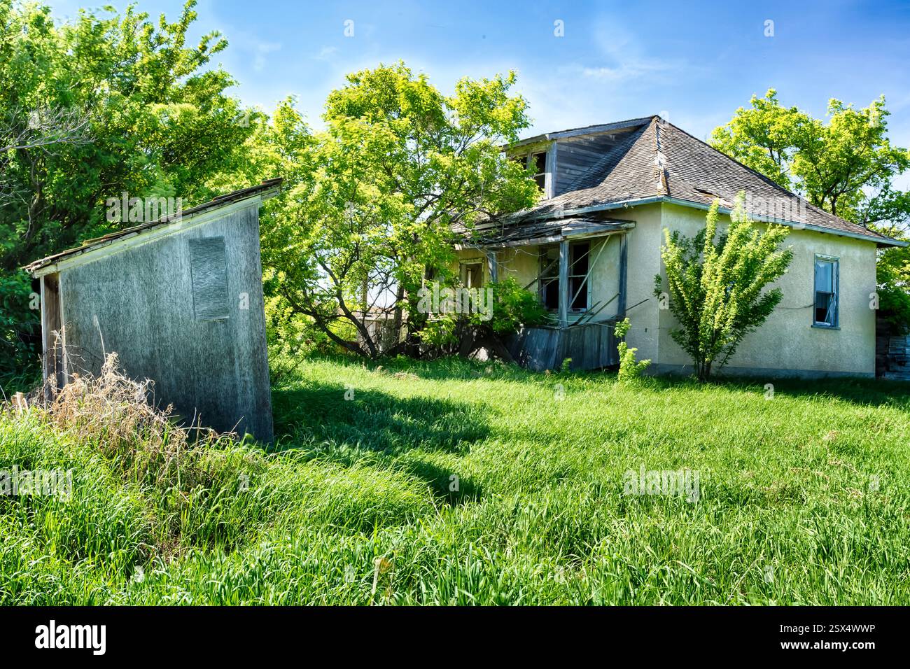 Haus mit einem Schuppen davor. Der Schuppen ist aus Holz und hat ein Dach Stockfoto