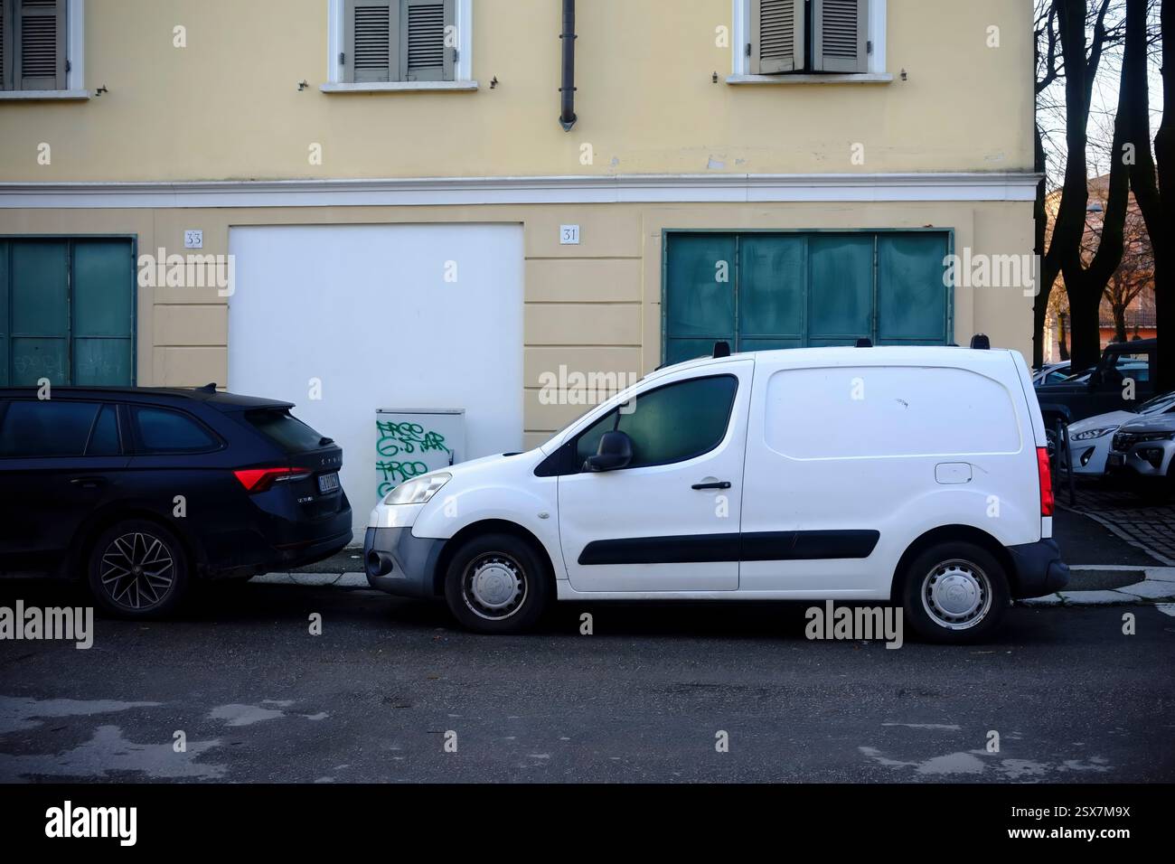 Cremona, Italien 9. Februar 2025 Weißer peugeot bipper Tipi und dunkler skoda pracht parkten auf einer Straße vor einem Wohngebäude Stockfoto
