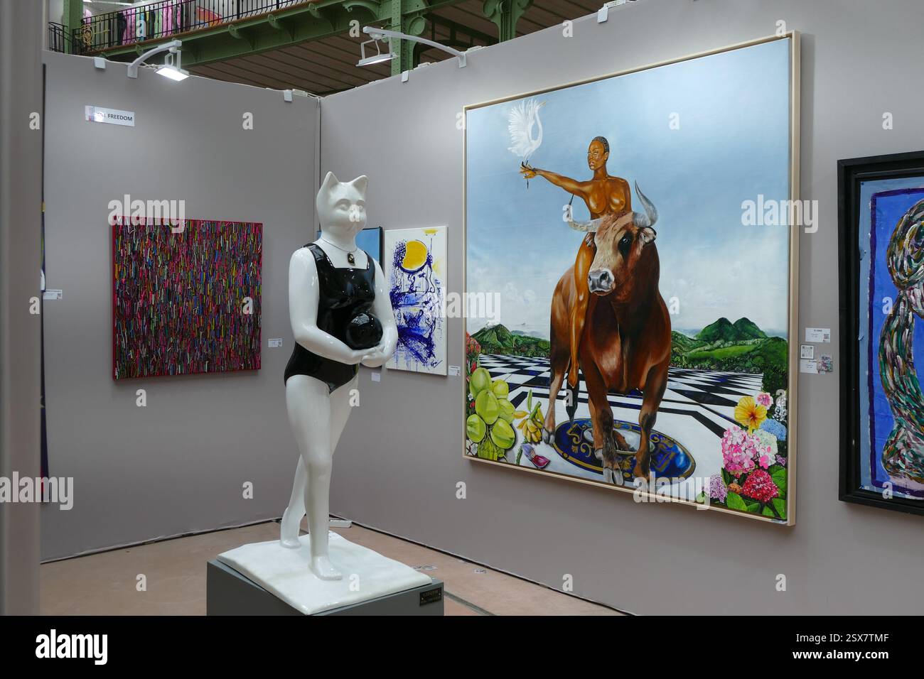 Paris, Frankreich. Februar 2025. In der Lounge befindet sich eine Skulptur des deutsch-iranischen Künstlers Pari Ravan, die eine Frau mit Katzenkopf darstellt, und dahinter ein Gemälde einer Westindianerin auf einem Stier des guadeloupeischen Künstlers D. Luidgi, das während der Ausstellung zu sehen war. DIE KUNSTHAUPTSTADT stellt 2.000 Künstler aus allen Disziplinen aus. In diesem Jahr stehen asiatische Künstler im Mittelpunkt. Zurück im Grand Palais, wo die Universalausstellungen stattfanden, lädt DIE KUNSTHAUPTSTADT Sie zurück zu der großen jährlichen Kunstausstellung im Herzen von Paris. (Foto: Gregory Herpe/SOPA Images/SIPA USA) Credit: SIPA USA/Alamy Live News Stockfoto