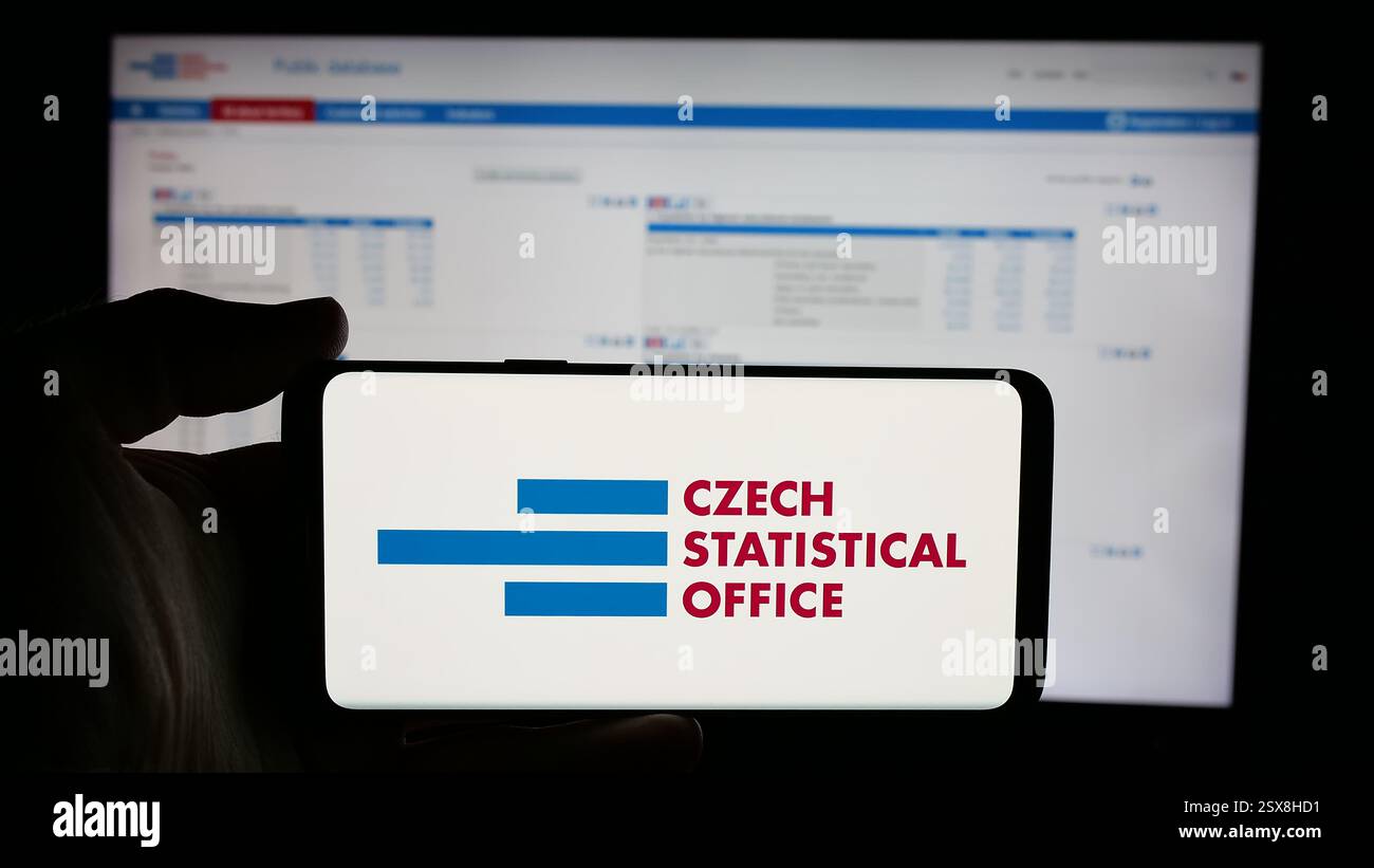 In dieser Abbildung befindet sich ein Mobiltelefon mit dem Logo des tschechischen Statistischen Amtes (CSO) auf dem Bildschirm vor der Webseite. Stockfoto