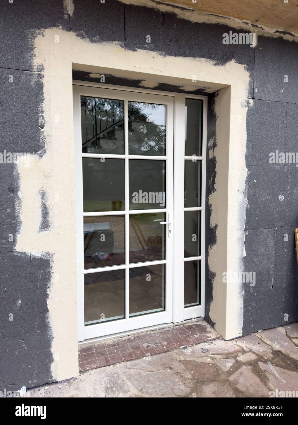 Die Renovierungsarbeiten zeigen eine moderne Türinstallation in rustikaler Umgebung Stockfoto