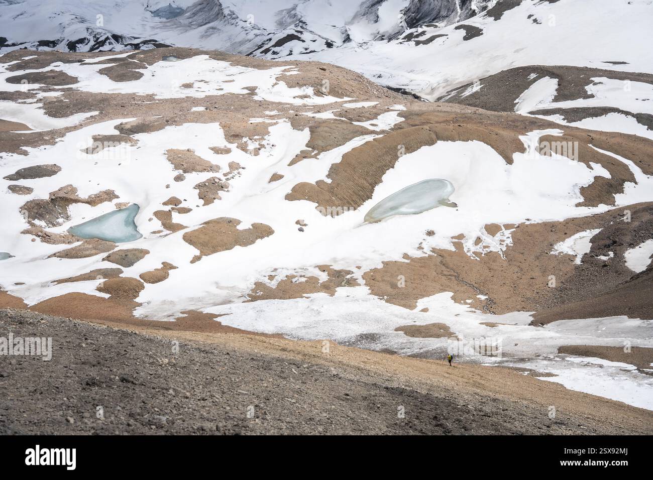 Einsamer winziger Wanderer in einer riesigen alpinen Gletscherlandschaft, Pamir Mountains, Kirgisistan Stockfoto