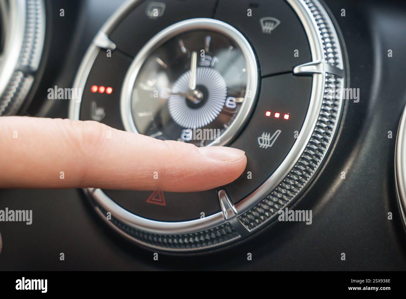 Beim Einschalten der dreistufigen Sitzheizung im Auto drückt der Finger die Taste. Kfz-Bedienfeld für mühelose Fingereinstellungen Stockfoto