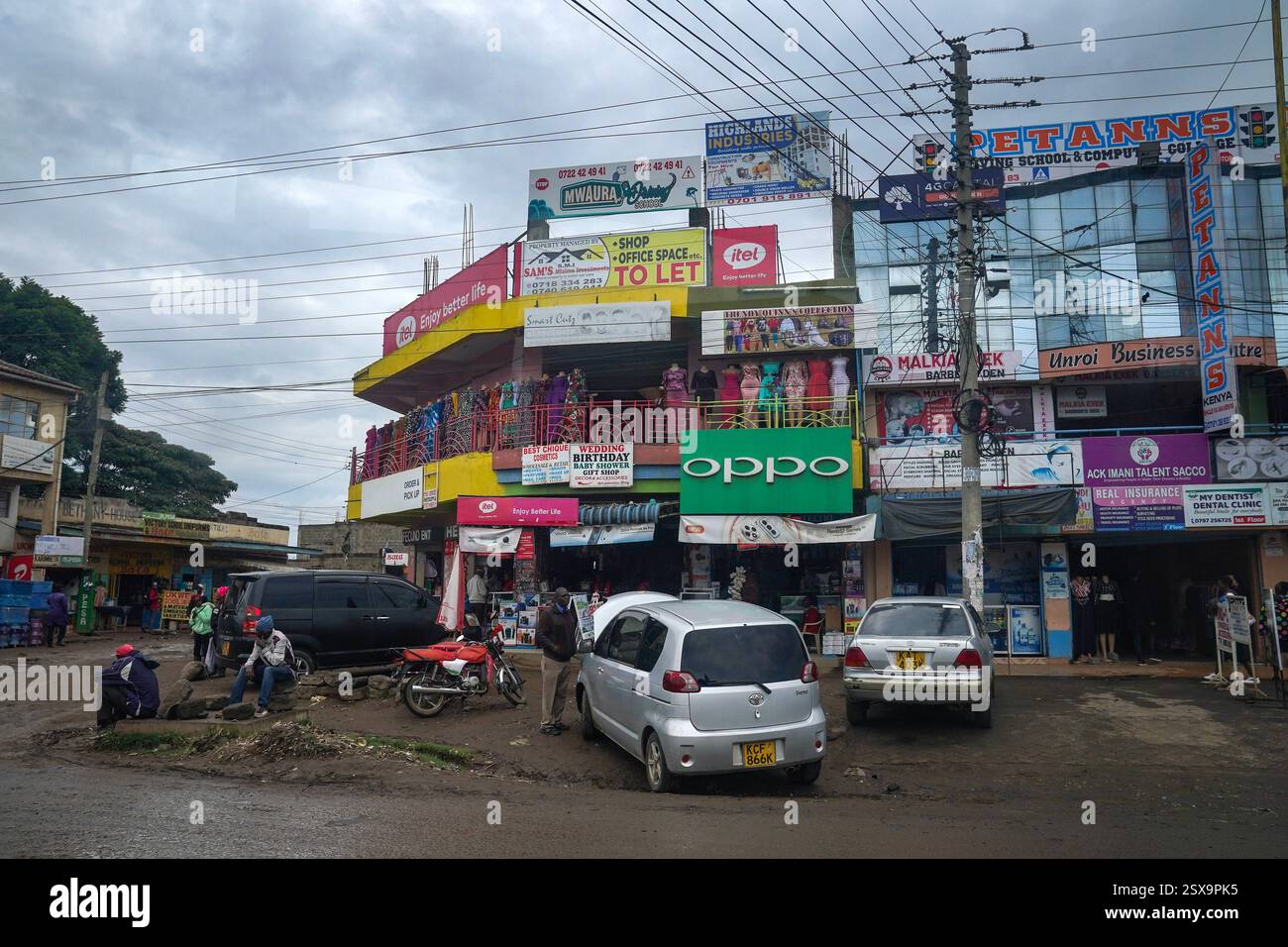 Daily Life in Gilgil, Kenia Ein allgemeiner Blick auf eine Straßenecke mit einem mit Werbeschildern überdachten Baustein in Gilgil, Kenia am 30. Januar 2025. Gilgil ist eine kleine, aber lebendige Stadt im Nakuru County, Kenia, am Rande des Great Rift Valley. Gilgil ist traditionell für seine landwirtschaftlichen Wurzeln bekannt und hat sich zunehmend zu einem Drehkreuz für Kleinunternehmen entwickelt, was die umfassenderen wirtschaftlichen Veränderungen in Kenia widerspiegelt. Lokale Unternehmer nutzen die robuste Telekommunikationsinfrastruktur der Nationen, die für Innovationen wie mobile Gelddienste bekannt ist, um sich mit breiteren Märkten und zu verbinden Stockfoto