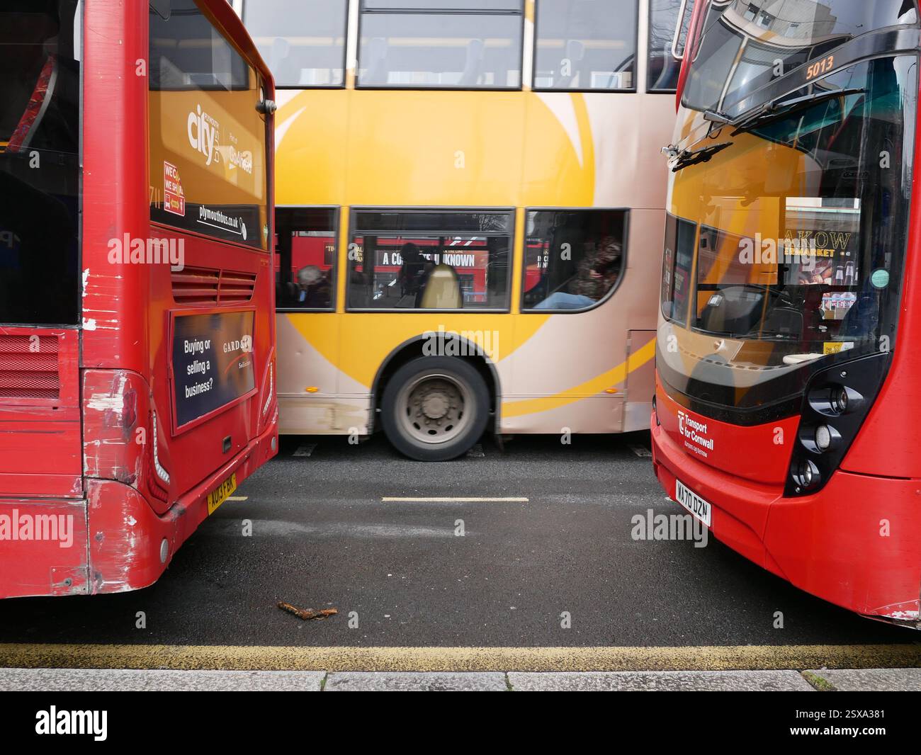 Gelber Bus und rote Busse. Öffentliche Verkehrsmittel Busse im Stadtzentrum. Plymouth, Devon Großbritannien Stockfoto