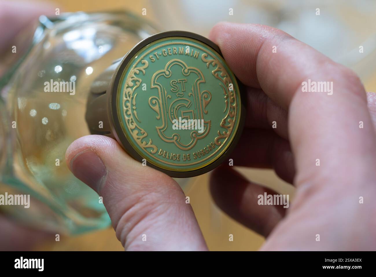 Die Hand des Mannes löst einen Schraubverschluss auf einer Flasche St-Germain, ein französischer Likör aus frischen Holunderblüten, der einmal im Jahr im späten Frühjahr von Hand gepflückt wird Stockfoto