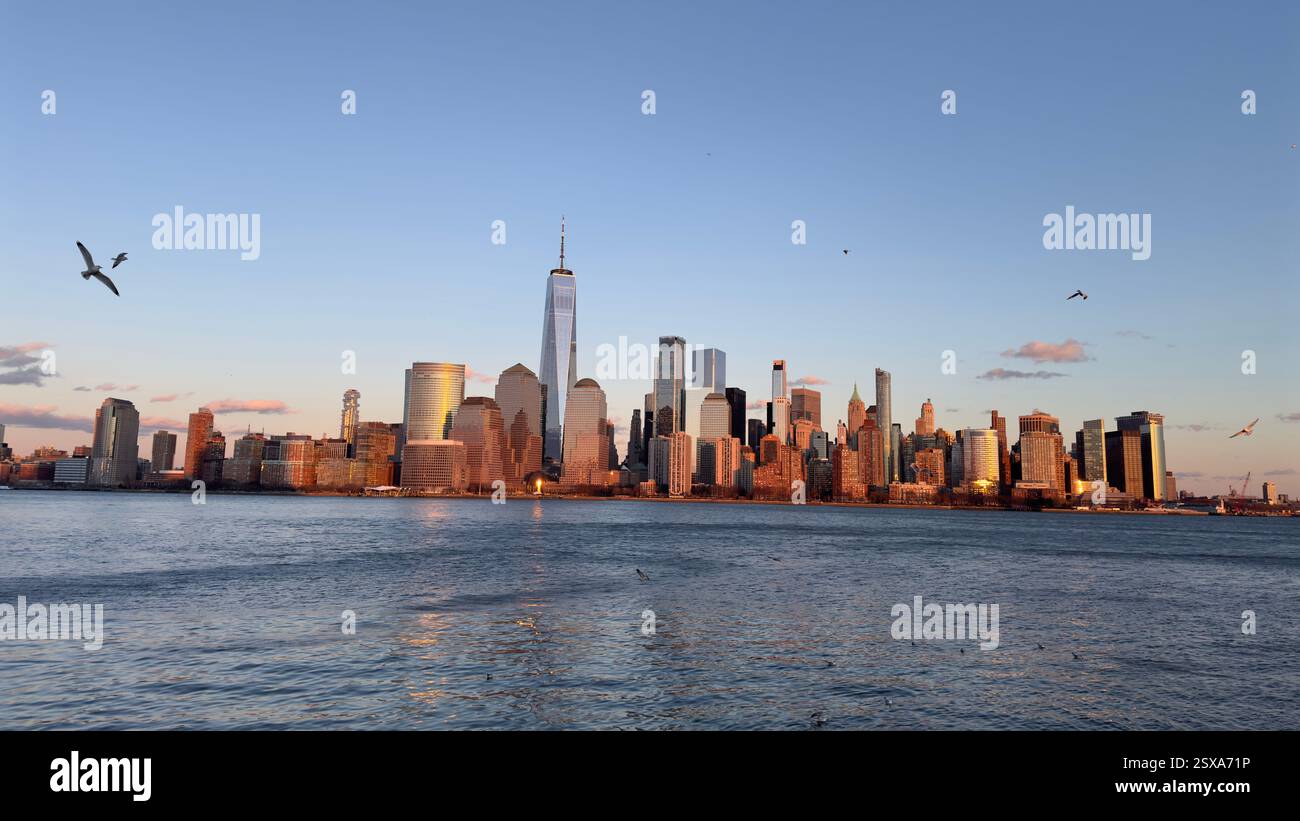 Skyline von New York City bei Sonnenuntergang mit beleuchteten Wolkenkratzern und Hudson River Reflections - Smartphone-aufgenommenes Stockfoto
