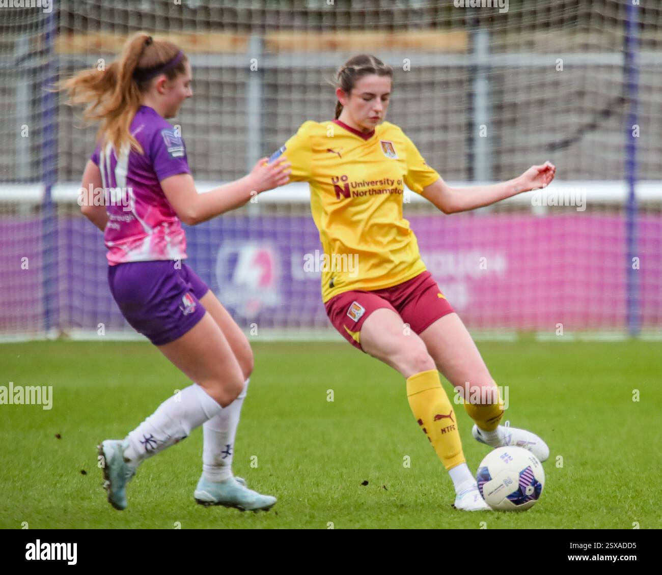 Loughborough, Vereinigtes Königreich. Februar 2025. Ruby Heselden spielt den Ball unter dem Druck von Jess Collyer vom Loughborough Lightning Football Club in der FA Women's National League Division One Match Loughborough Lightning gegen Northampton Town Women. Quelle: Clive Stapleton/Alamy Live News Stockfoto