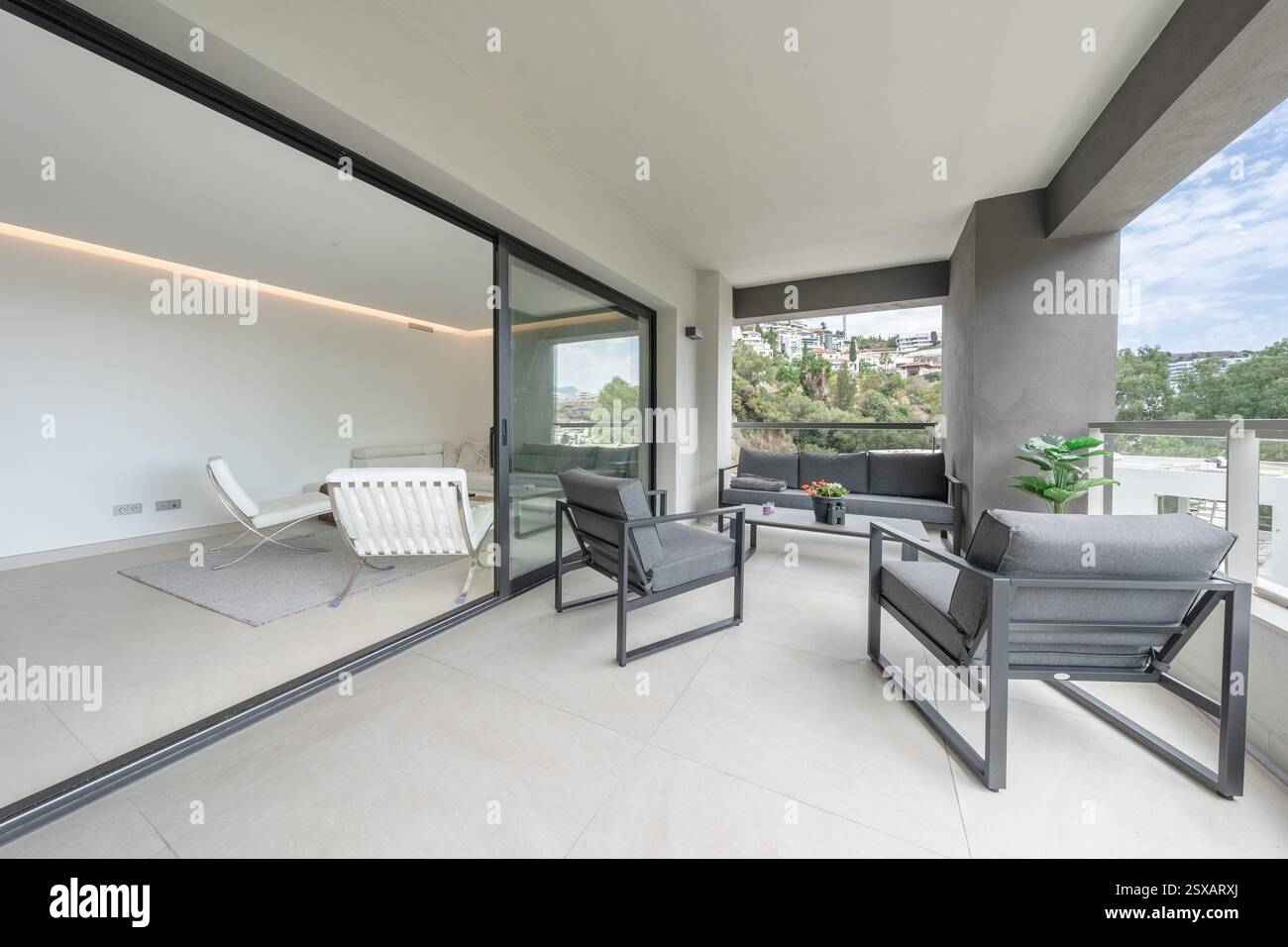 Nahaufnahme einer offenen Balkonterrasse, die zu einem luxuriösen mediterranen Apartment führt Stockfoto