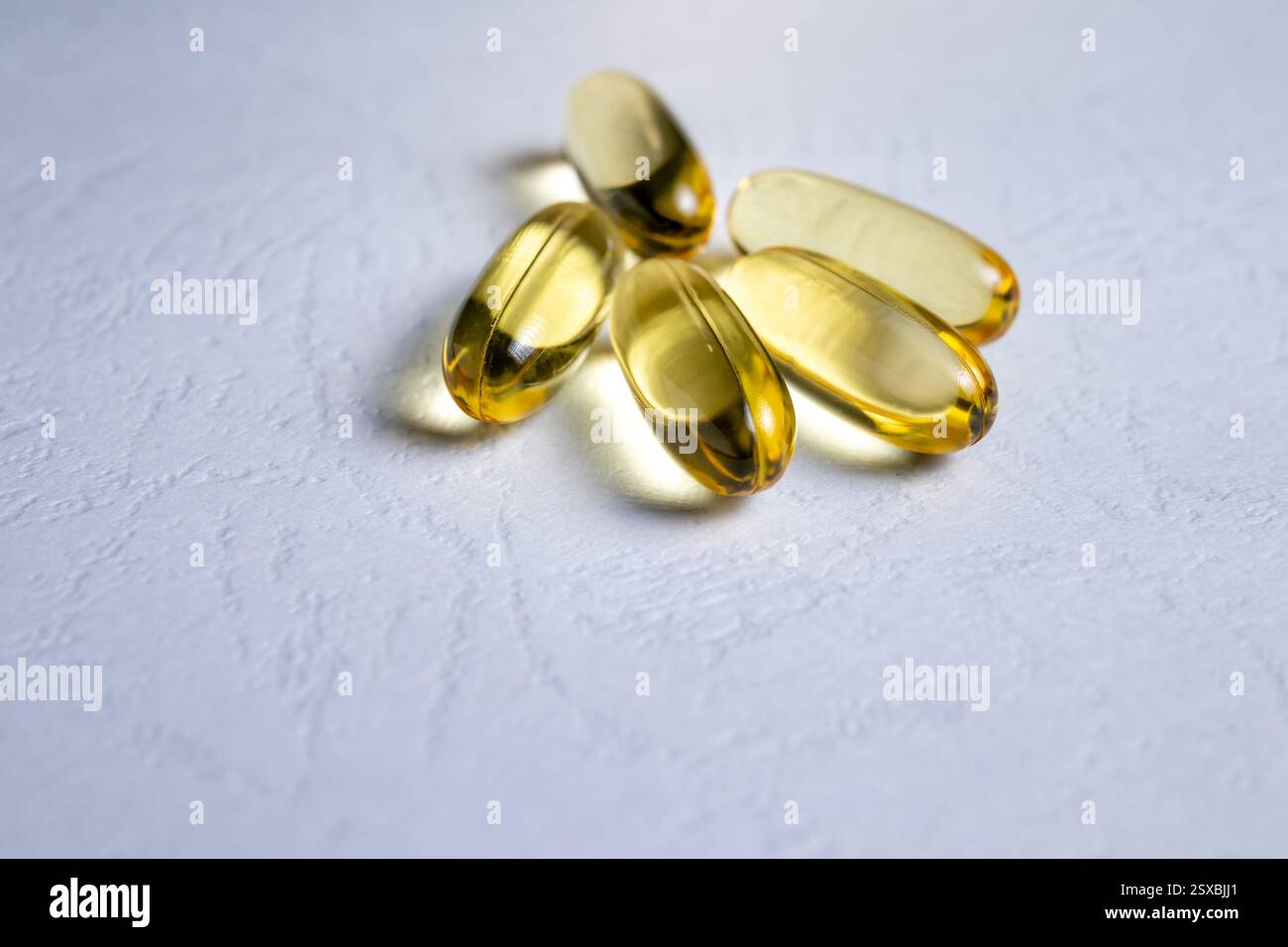 Omega-3 Fischölkapseln auf strukturierter Oberfläche Stockfoto