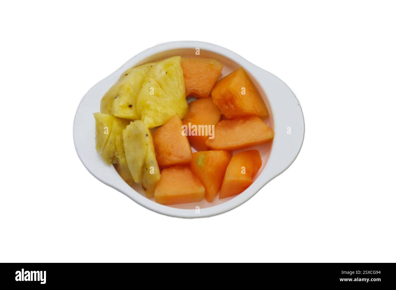 Frisch geschnittene Ananas- und Papaya-Stücke in einer weißen Schüssel isoliert auf weiß Stockfoto