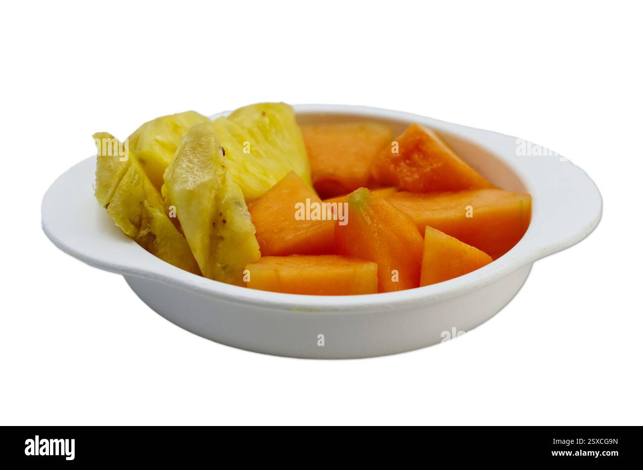 Frisch geschnittene Ananas- und Papaya-Stücke in einer weißen Schüssel isoliert auf weiß Stockfoto