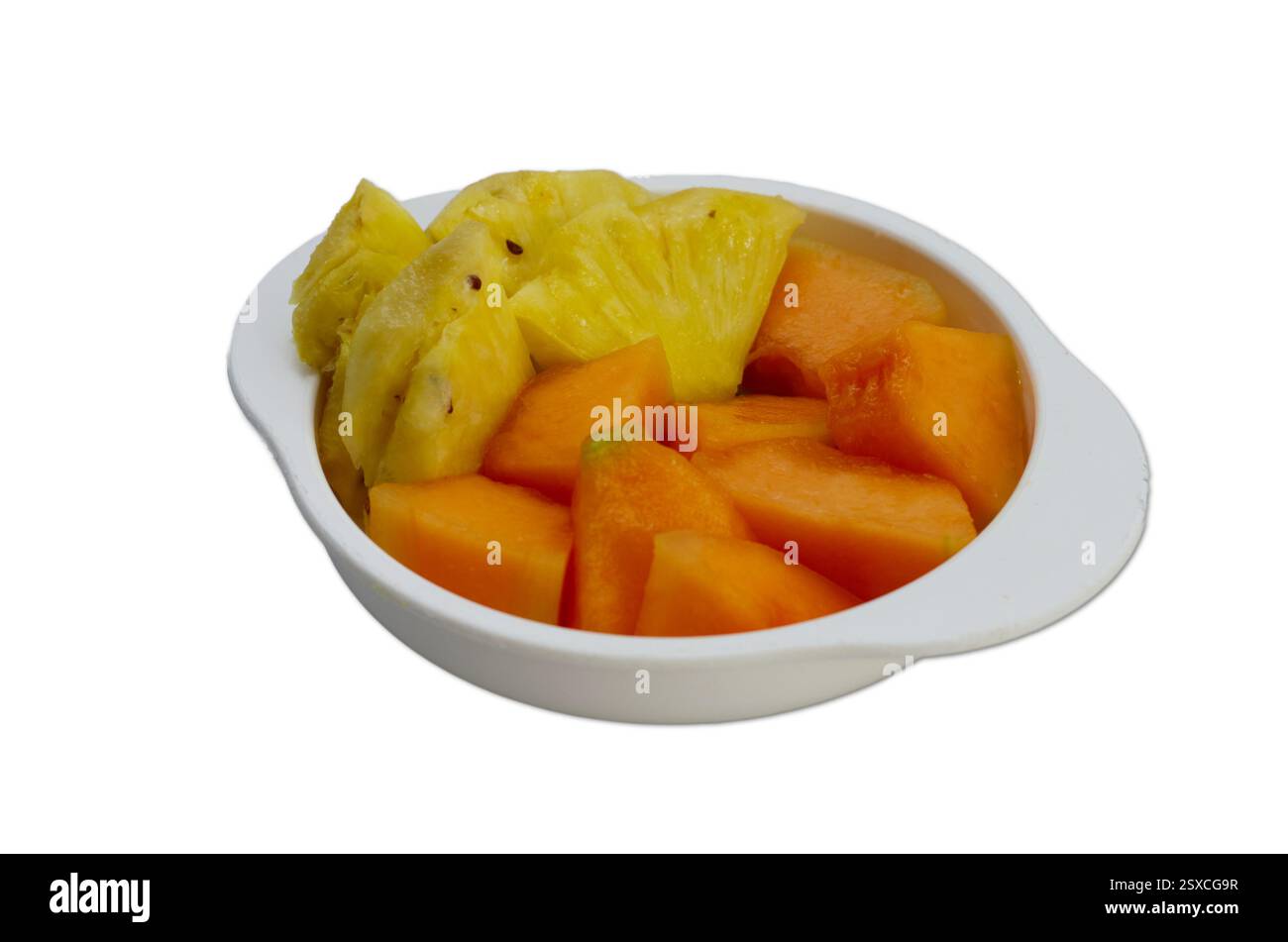 Frisch geschnittene Ananas- und Papaya-Stücke in einer weißen Schüssel isoliert auf weiß Stockfoto