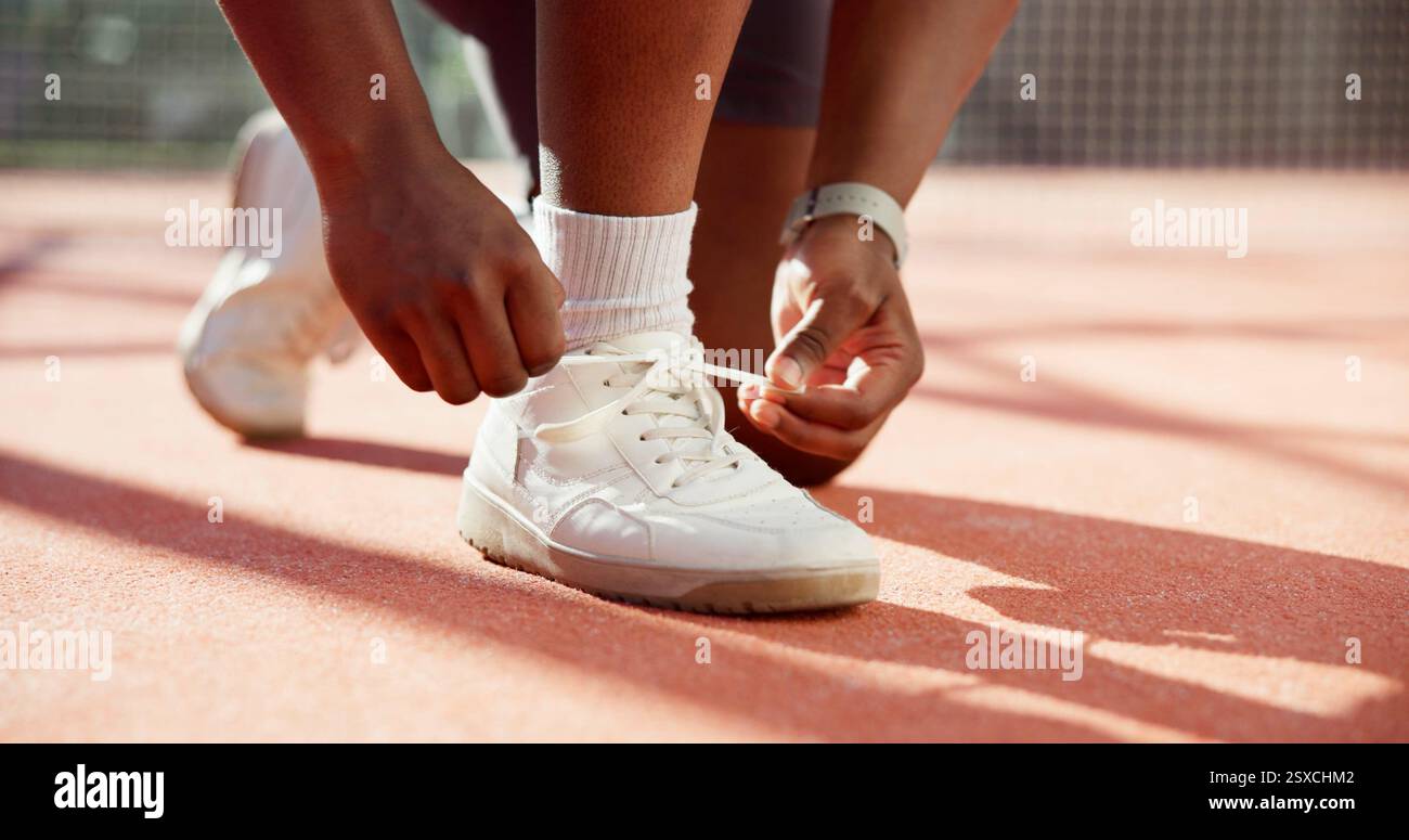 Person, Hände und Binderschuhe mit Fitness für Sport, Workout oder Outdoor-Übungen auf Rasen oder auf dem Platz. Nahaufnahme, Sportler oder Läufer, die sich mit Krawatte vorbereiten Stockfoto