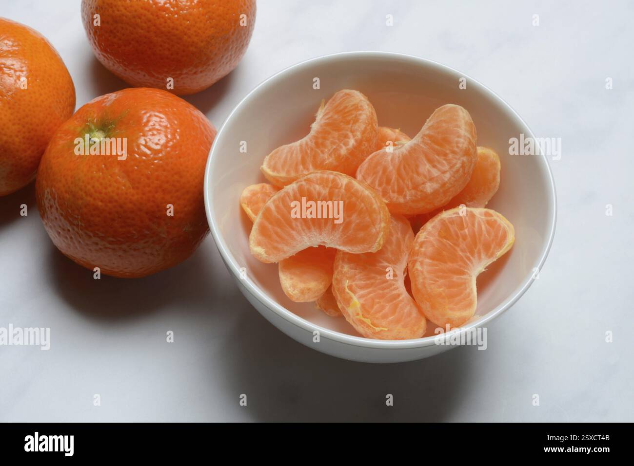 Clementinen und Clementinstücke in Schalen, Clementine Stockfoto