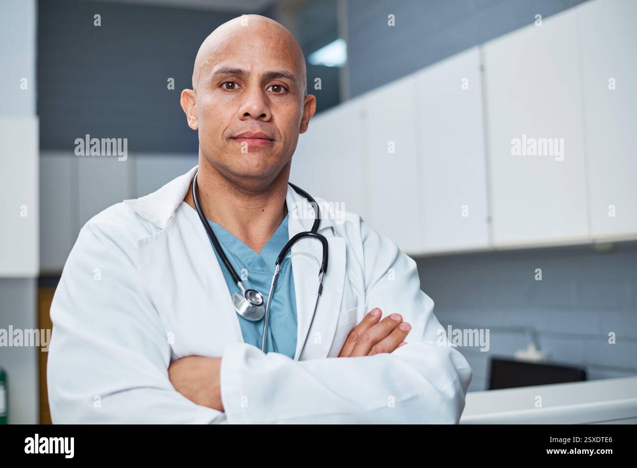 Erfahrener männlicher Arzt posiert selbstbewusst in einer Klinik, die Führung und medizinische Professionalität darstellt Stockfoto