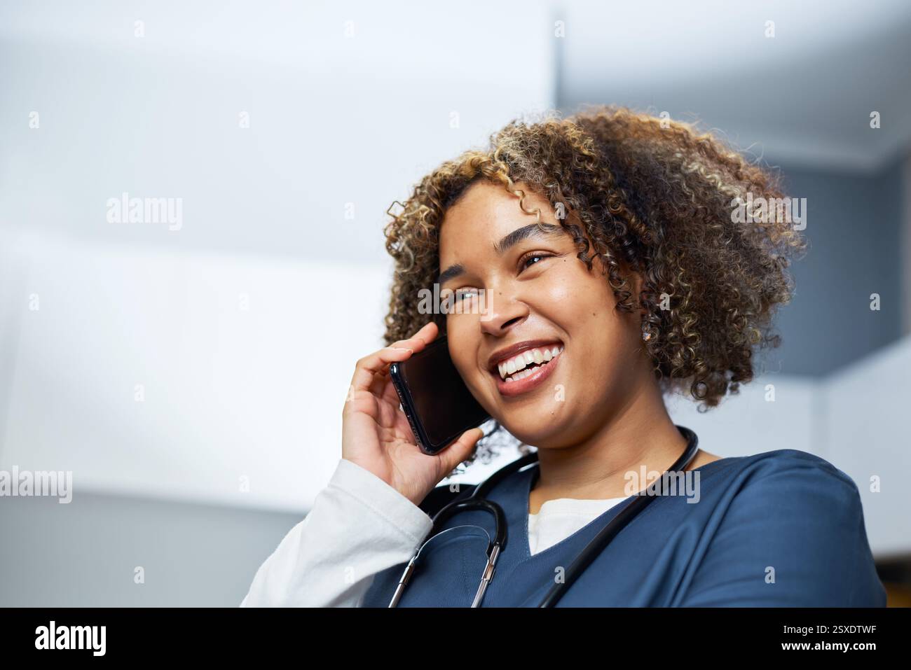Lächelnder medizinischer Fachmann, der im Büro auf dem Smartphone spricht Stockfoto