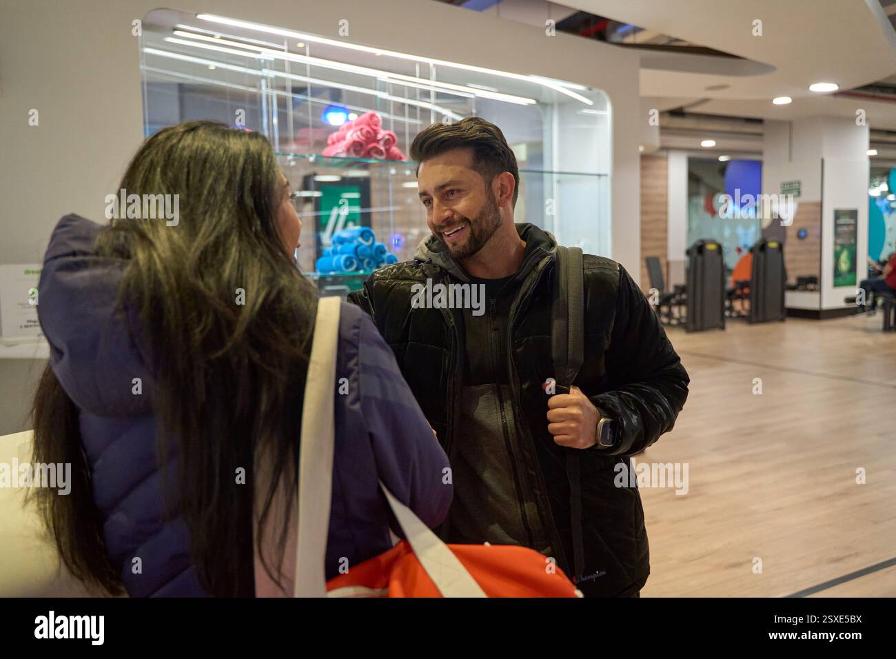Zwei Kollegen führen ein freundliches Gespräch in einem modernen Büroumfeld, in dem Teamarbeit und Kommunikation in einer professionellen Umgebung vorgestellt werden Stockfoto