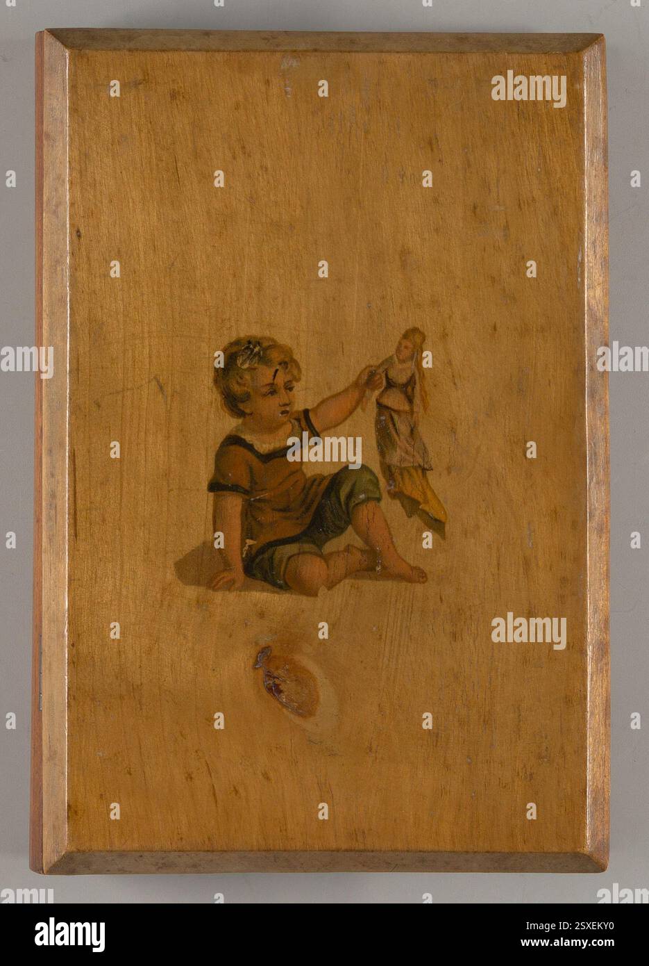 Kinderlackierkasten (1875-1885) in Buchform mit lackierter Außenseite und Kinderaufkleber. Im Inneren befinden sich Aquarelltabletten, eine Porzellanschale und ein herausnehmbares Tablett mit Fächern, die mit Blumenpapier ausgelegt sind. Stockfoto