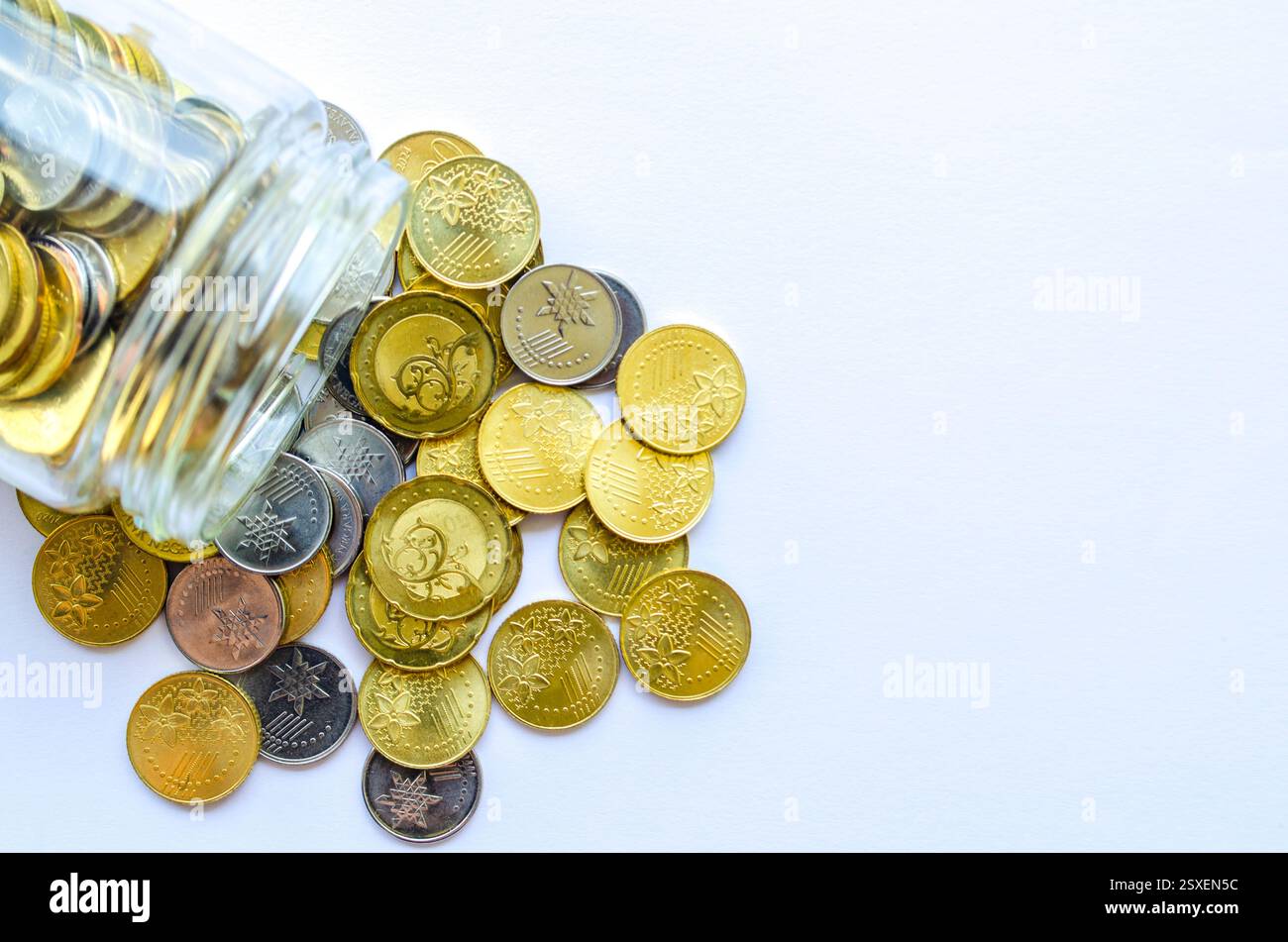 Draufsicht der goldenen Münzen in einem Glas mit anpassbarem Platz für Text. Konzept für Kopierbereich. Stockfoto