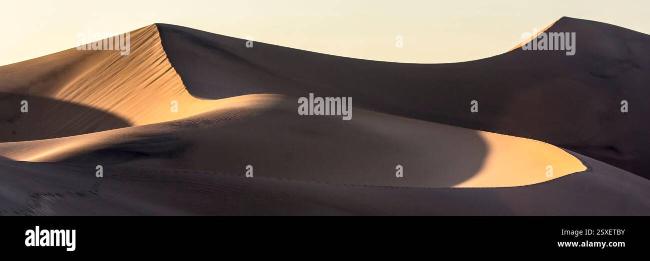 Sandiger Hügel mit Schatten darauf. Der Schatten ist auf der rechten Seite des Hügels Stockfoto