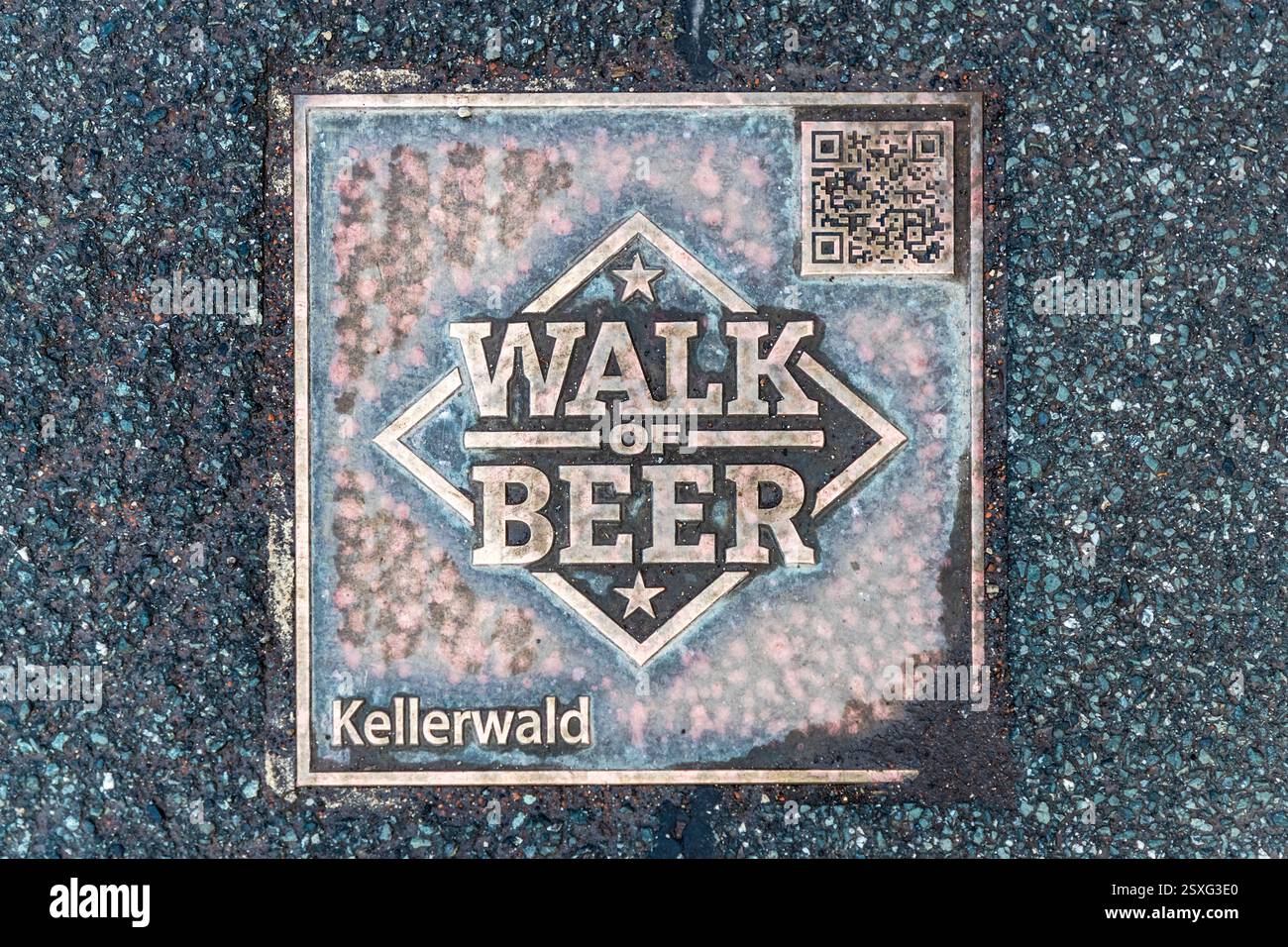 Eine Bronzetafel mit der Aufschrift „Kellerwald“ und einem QR-Code, die als „Walk of Beer“ bezeichnet wird, ist am Rand des Kellerwalds in Forchheim in den Bürgersteig eingelassen. Der Weg markiert die Brauartradition von Forchheim. Der Kellerwald umfasst 23 Bierkeller, die in Sandstein über etwa 20.000 Quadratmeter hineingehauen wurden. Die ersten Keller sind aus dem Jahr 1691 dokumentiert. Auf den Kellern, Forchheim, Bayern, Deutschland. Stockfoto