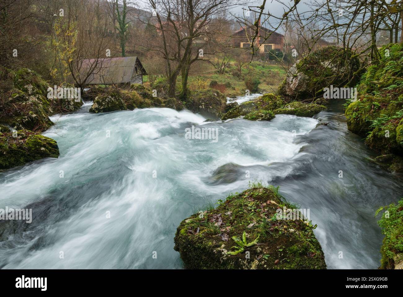 Kaskaden am schnellen Bergbach Krupa mit Holzmühlen, klarem Wasser mit türkisfarbener Farbe Stockfoto