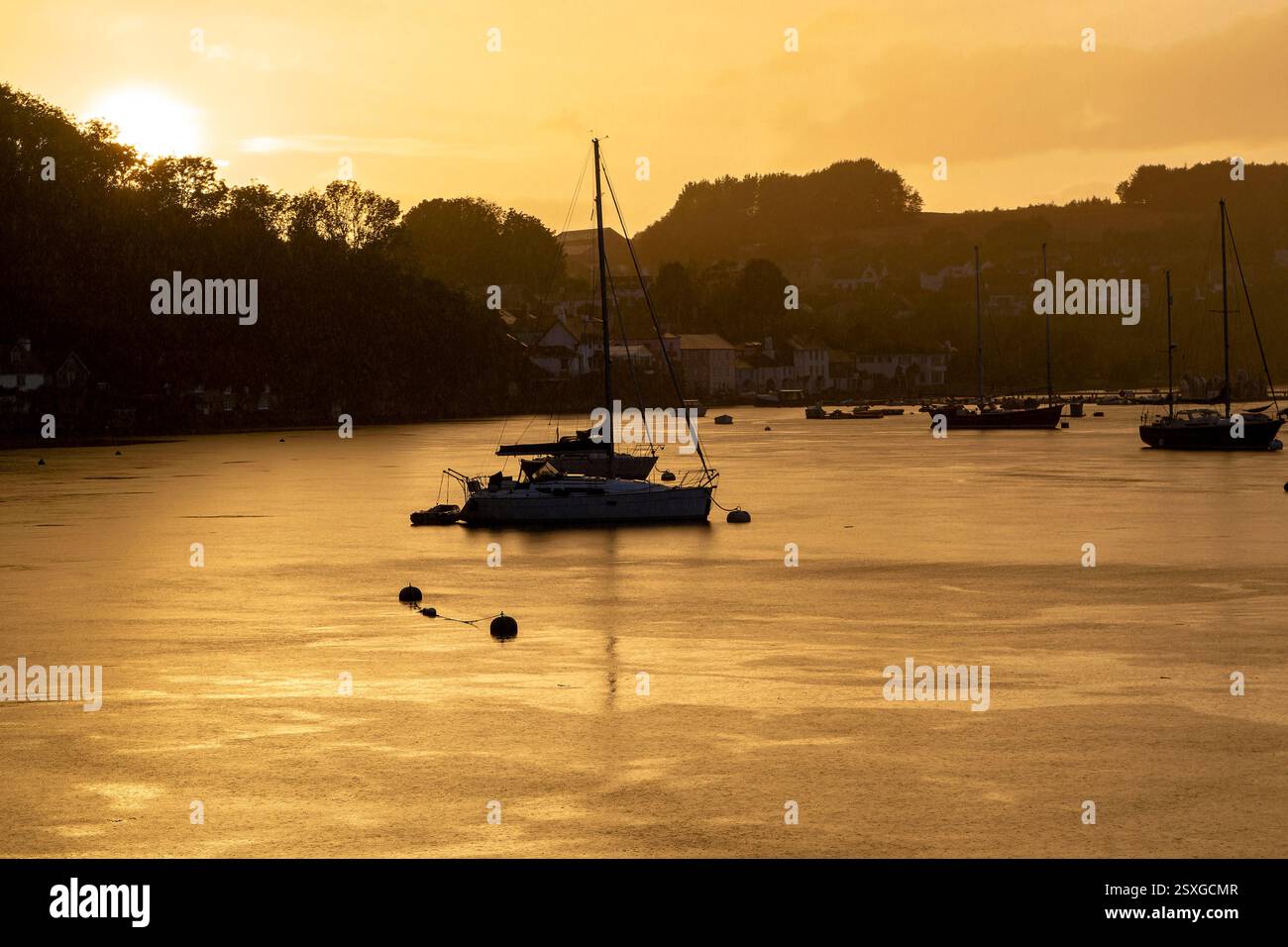 Farbenfroher, goldener Sonnenuntergang mit Blick auf den Fluss Dart nach Dittisham. Blick Auf Den Fluss, Vertäute Boote, Farbenfrohe Wolken, Verglaster Fluss. Stockfoto Farbenfroher, goldener Sonnenuntergang mit Blick auf den Fluss Dart nach Dittisham. Blick Auf Den Fluss, Vertäute Boote, Farbenfrohe Wolken, Verglaster Fluss. Stockfoto