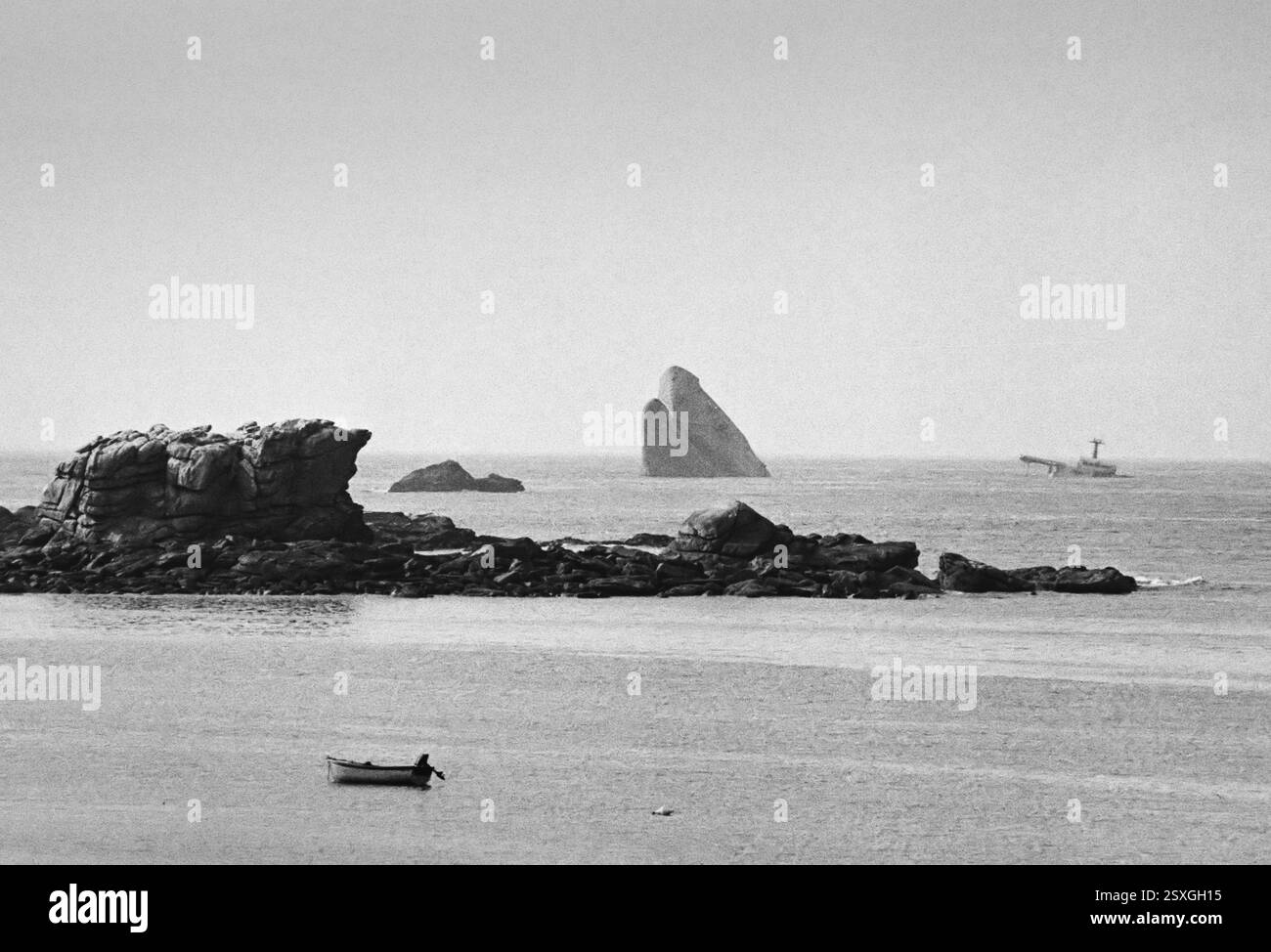 - Bretagne (Frankreich), Sommer 1978, am Horizont der Bug und die Überreste des Öltankschiffs Amoco Cadiz, der vor der bretonischen Küste sank und einen sehr schweren ökologischen Unfall verursacht hatte, weil Öl ins Meer und an die Küste gelangt ist. - Bretagna (Francia), Anwesen 1978, all'orizzonte la prua Ed i resti della petroliera Amoco Cadiz, affondata al largo delle coste Bretoni causando un gravissimo incidente ecologico per la fuoriuscita di petrolio nel Mare e sulla costa. Stockfoto