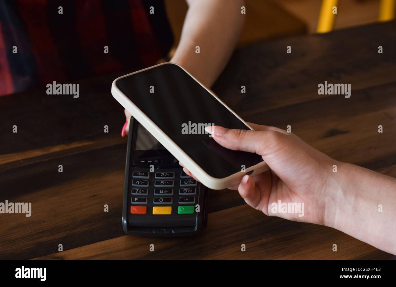 Hand der Person, die für den Kauf bezahlt, mit Nahaufnahme des Mobiltelefons Stockfoto