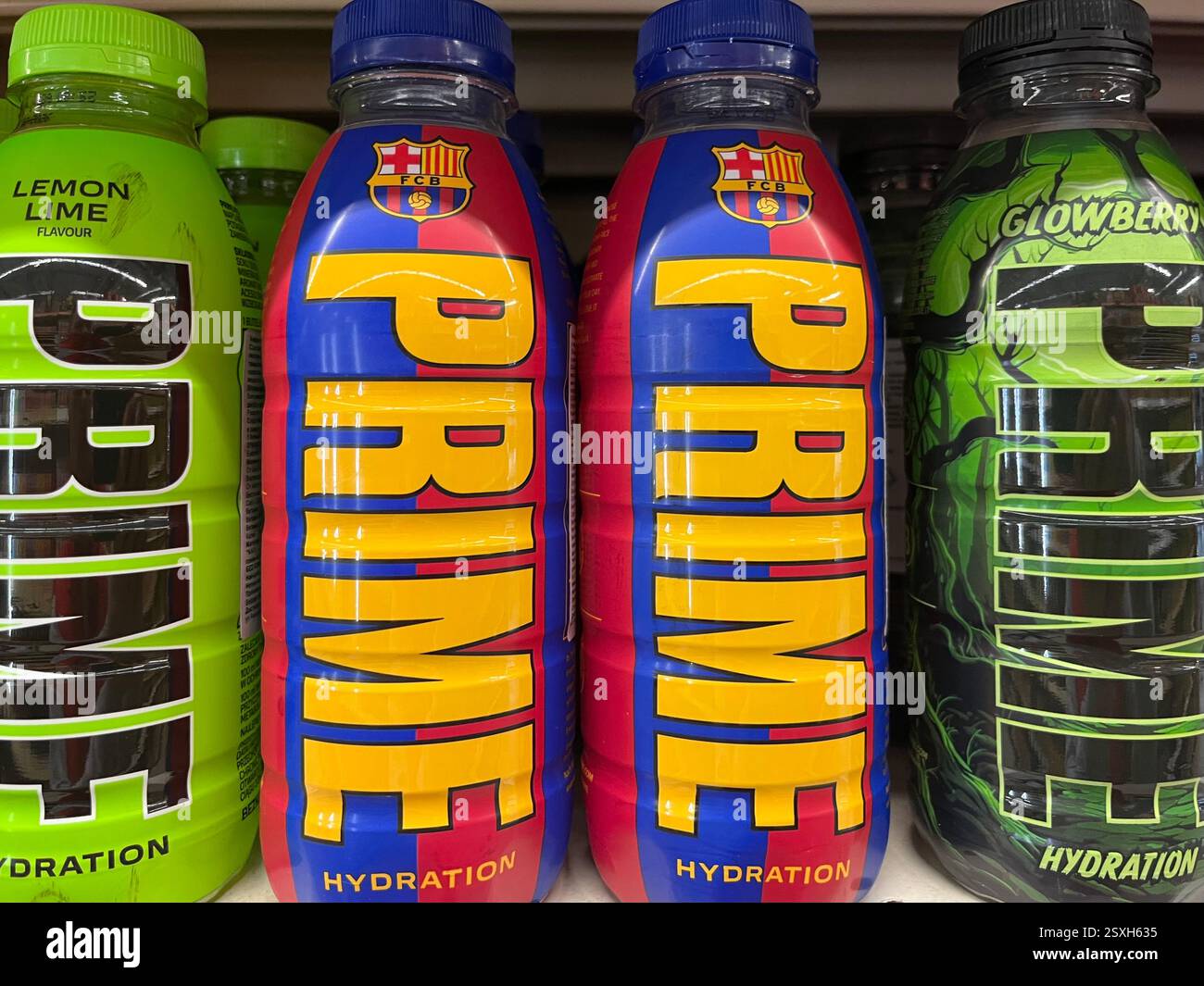 Flaschen mit Prime Hydration Drinks werden in einem Supermarktregal ausgestellt und zeigen verschiedene Geschmacksrichtungen und Verpackungen - Smartphone-aufgenommenes Stockfoto